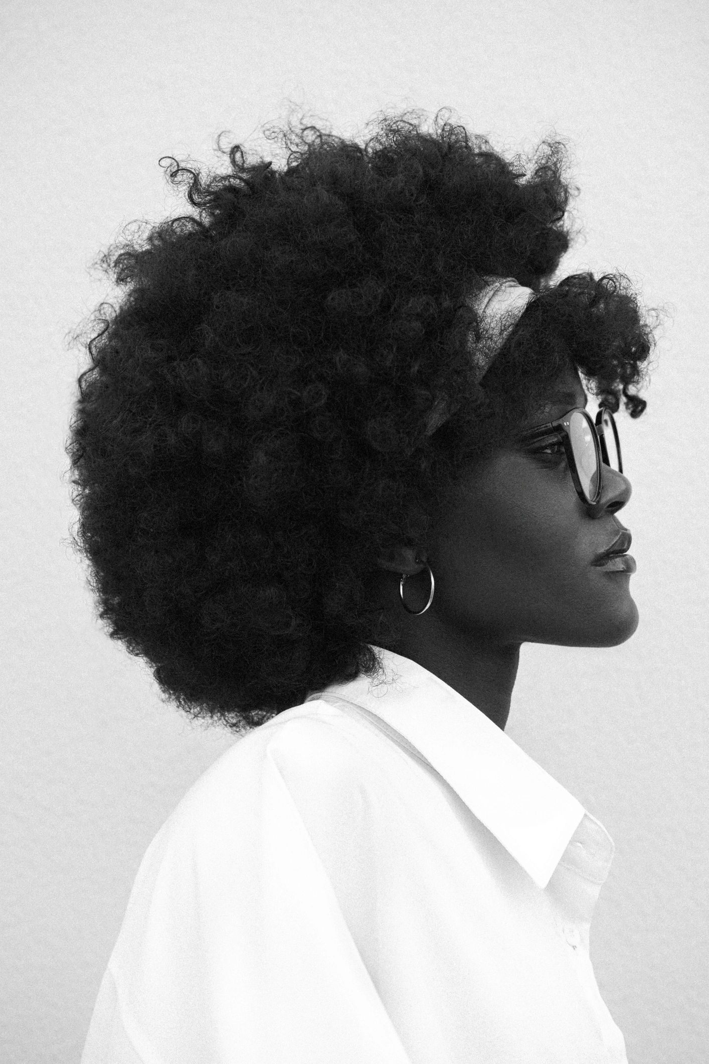 Black-and-white portrait of a thoughtful, stylish woman