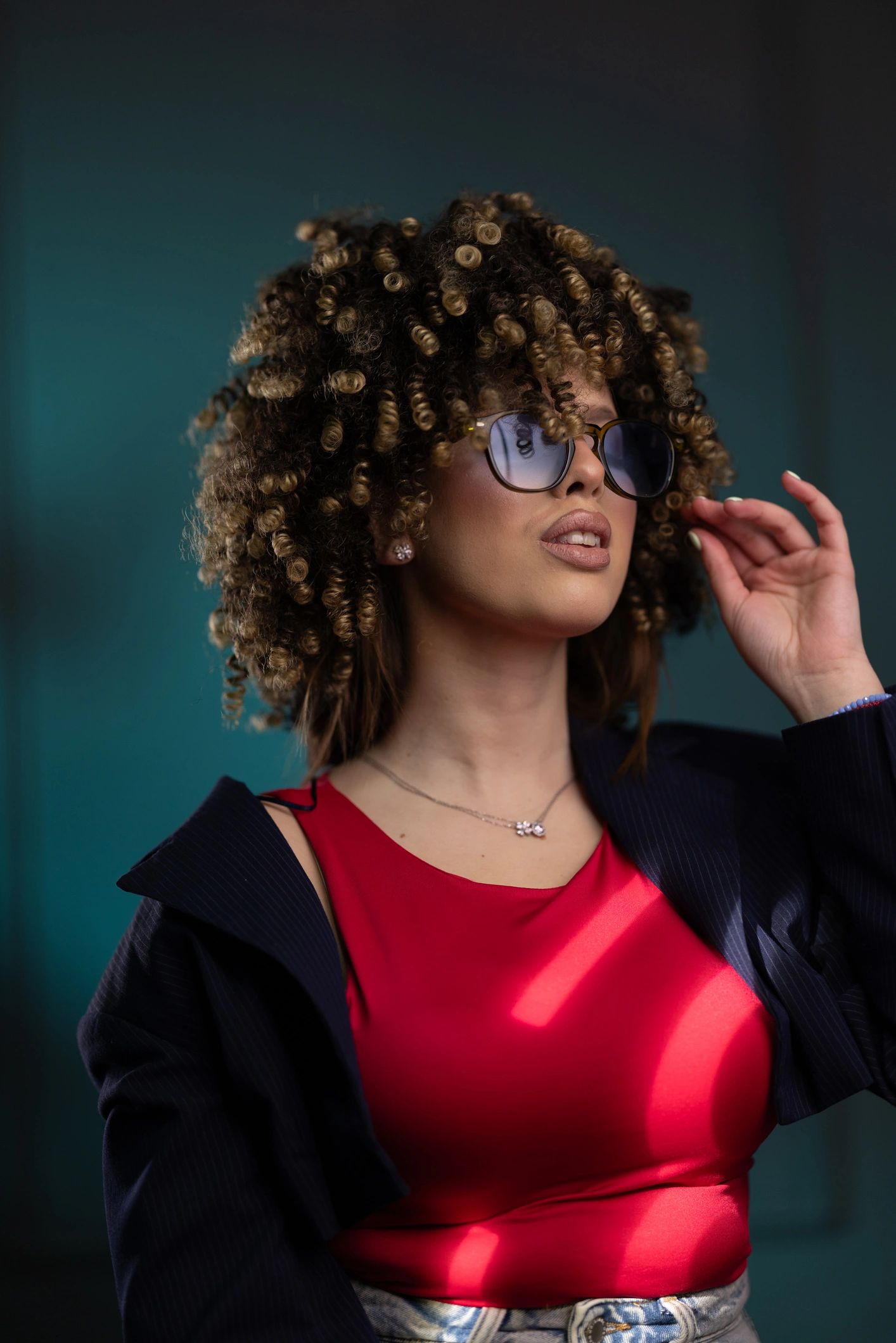 Stylish Young Woman With Curly Hair Wearing Sunglasses and Red Top Fashion Portrait